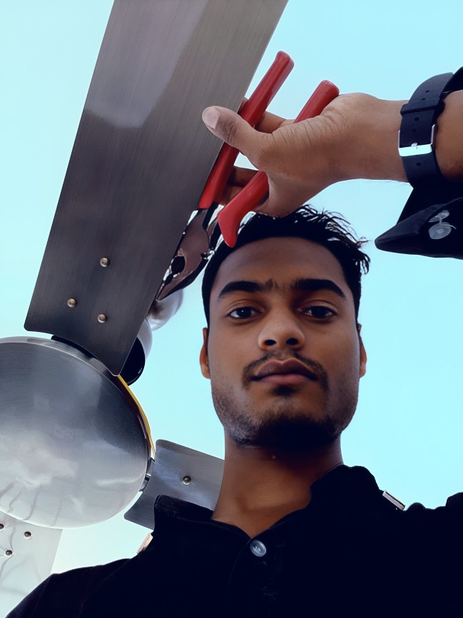 An electrician installing a modern ceiling fan.